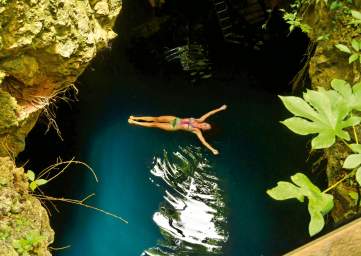 Woman Floating in Cenote Pool